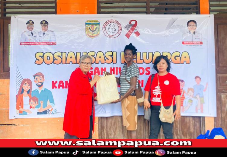Ketua Yayasan Melati Peduli Timika, Martha Pussung menyerahkan bingkisan Natal kepada perwakilan warga di Kompleks Asrama Iwaka, Jumat (19/12/2025)(Dokumen YMPT)